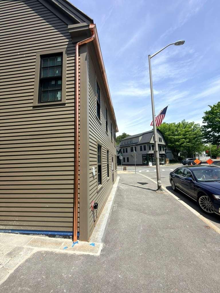 A single copper gutter run along the street elevation, no joints along its length