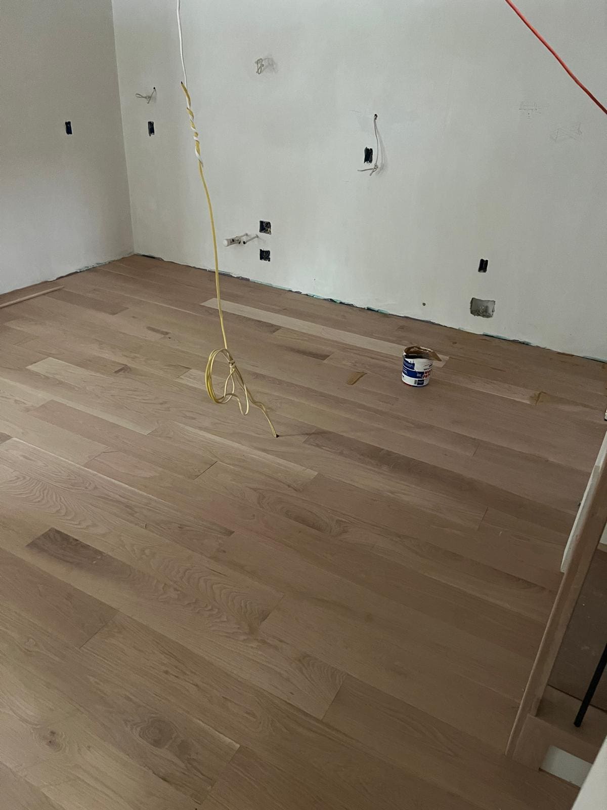 White oak boards laid the length of a room before the trim goes on