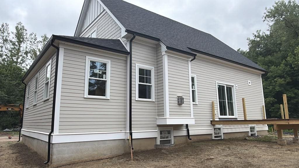 Seamless gutter along a gable end with the downspout carried down past the foundation