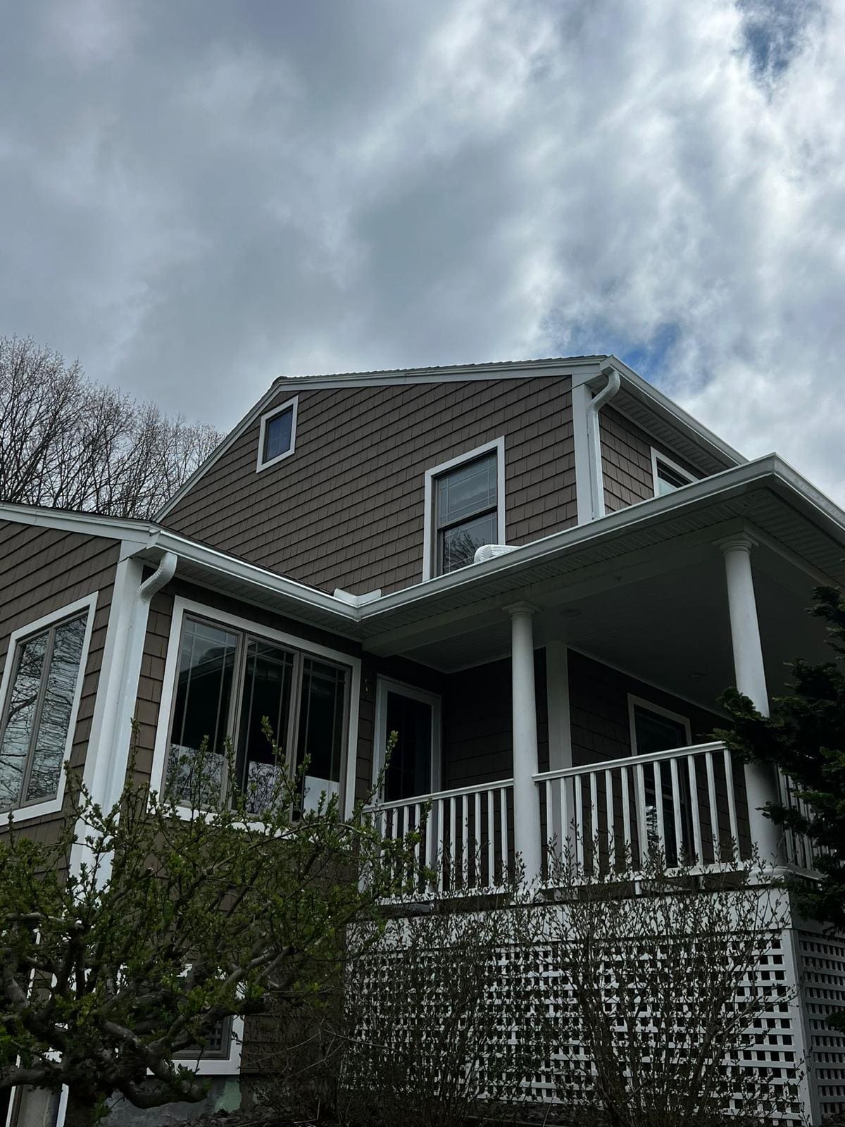 Gutters and downspouts around the roof valleys of a shingle-sided house