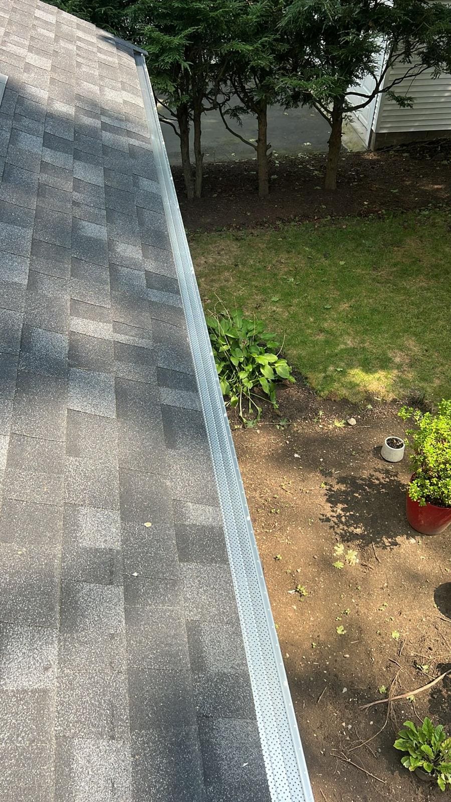 Leaf guard running round the corner of a roof, seen from the roof line