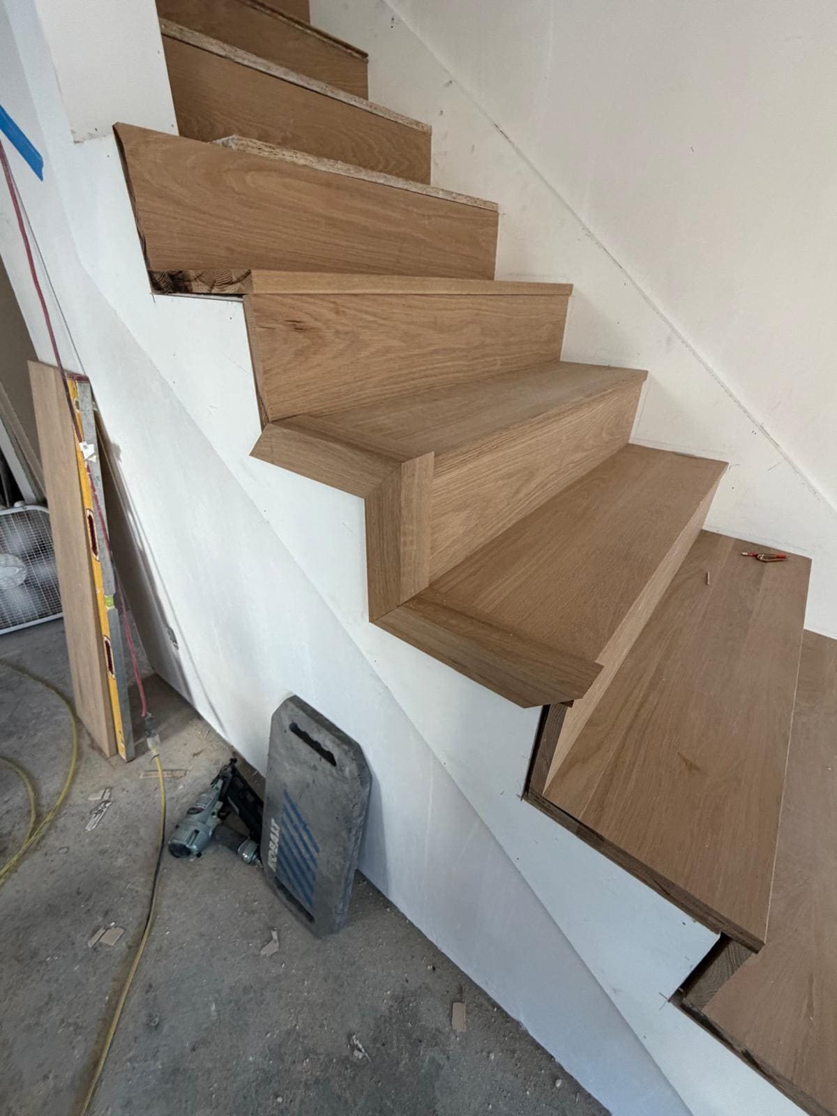 White oak treads and risers being fitted to a winder staircase