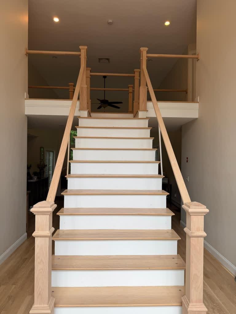Finished staircase with white risers, oak treads and turned newel posts
